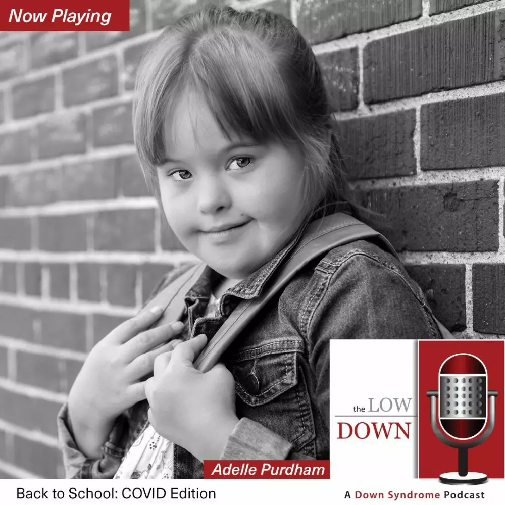 Girl with Down syndrome wearing backpack leaning against brick wall