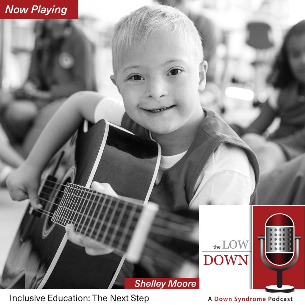 Boy with Down syndrome plays guitar as classmates look on