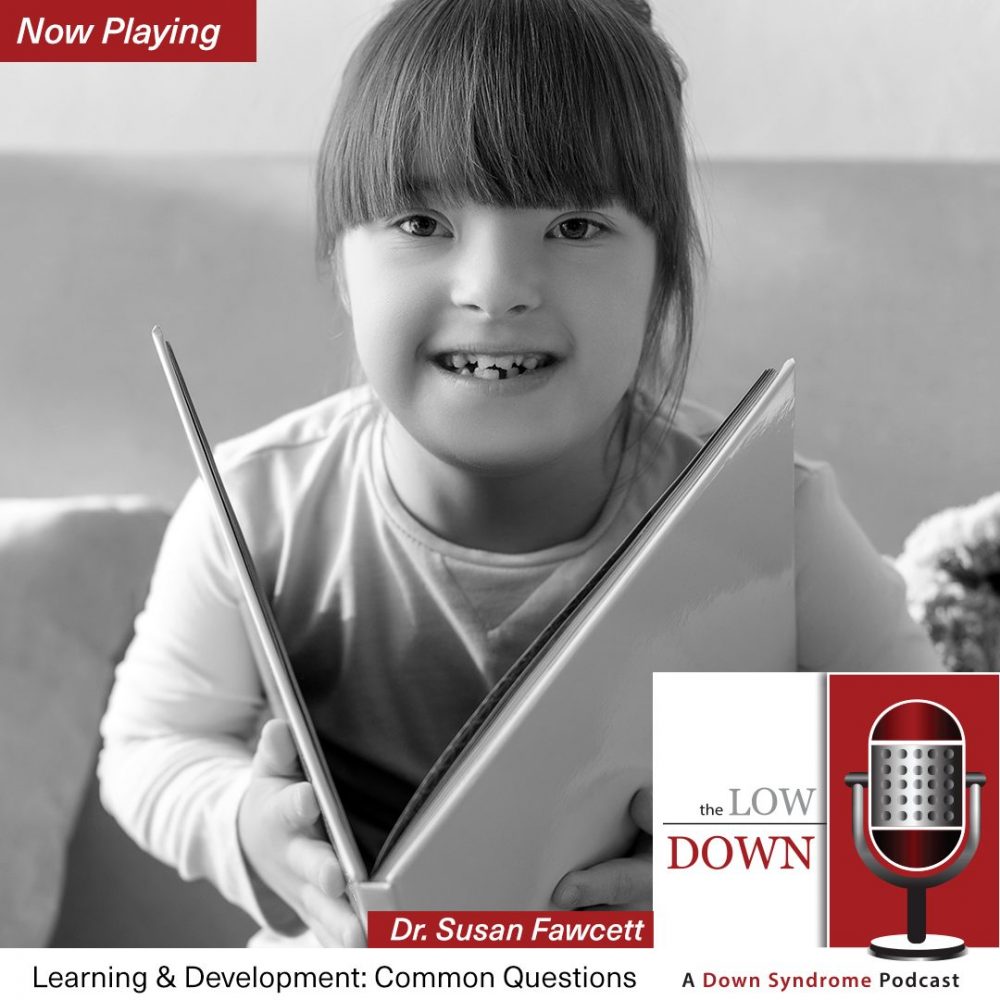 Smiling girl with Down syndrome holding open book