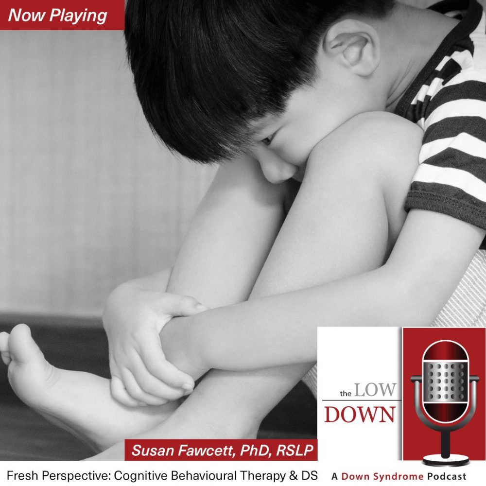 Sad Asian boy with Down syndrome hugs his knees