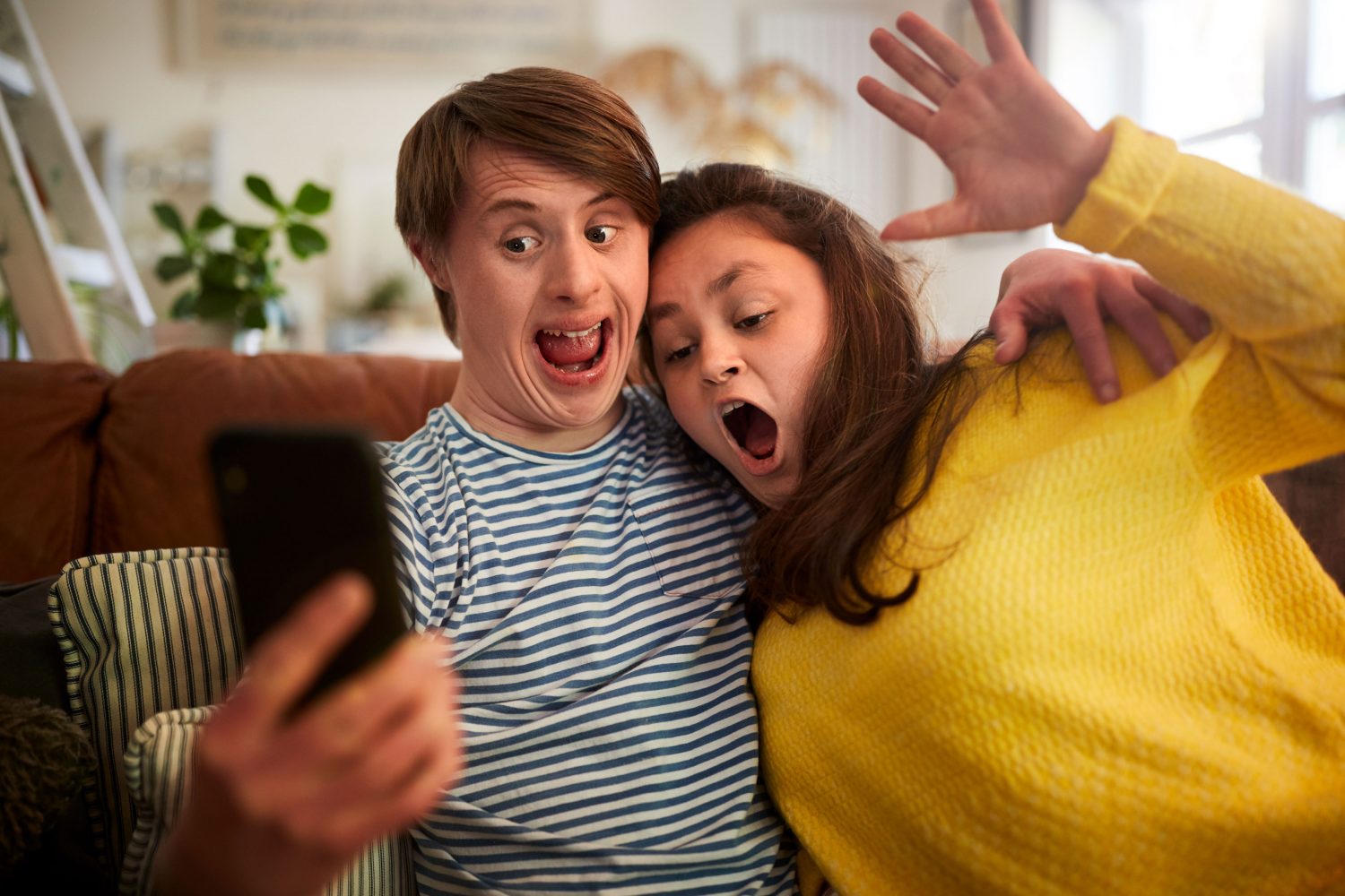 Couple with Down syndrome takes goofy selfie on the couch