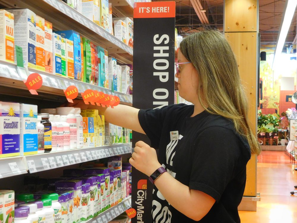 Woman with Down syndrome stocks shelves at grocery store