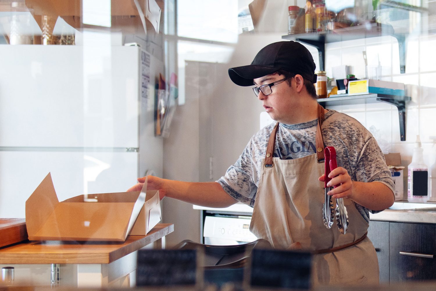 Young man with Down syndrome works in restaurant kitchen