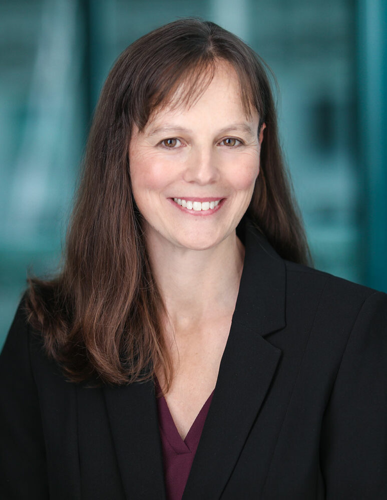 headshot of a caucasian woman in purple blouse and black jacket