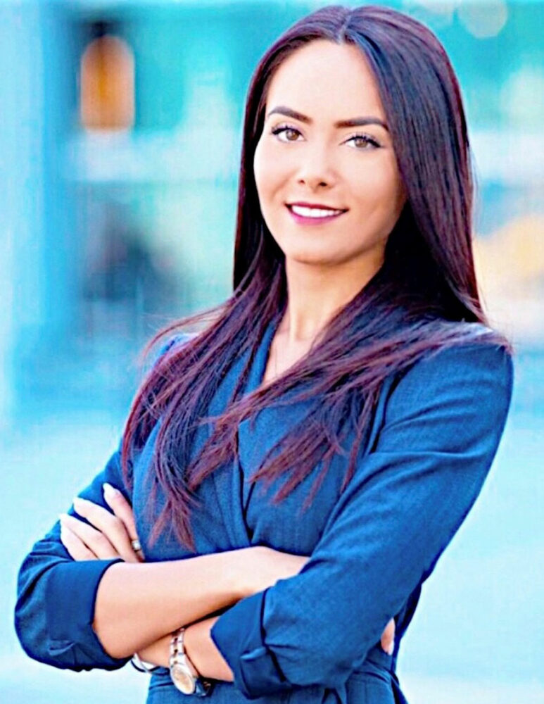 headshot of a woman with dark hair wearing a blue suit