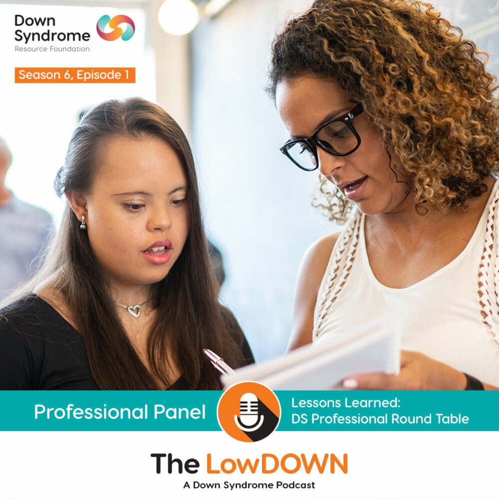 Caucasian woman with Down syndrome looks at paper with her female teacher