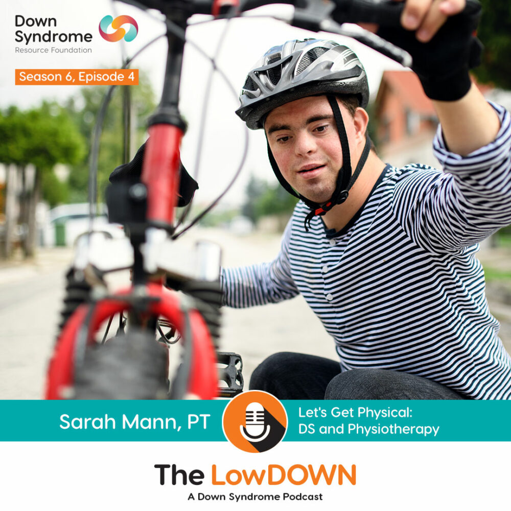 Teenage boy with Down syndrome wearing bicycle helmet crouches next to red bike
