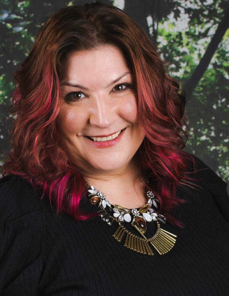 headshot of white woman with brown and pink hair and black top