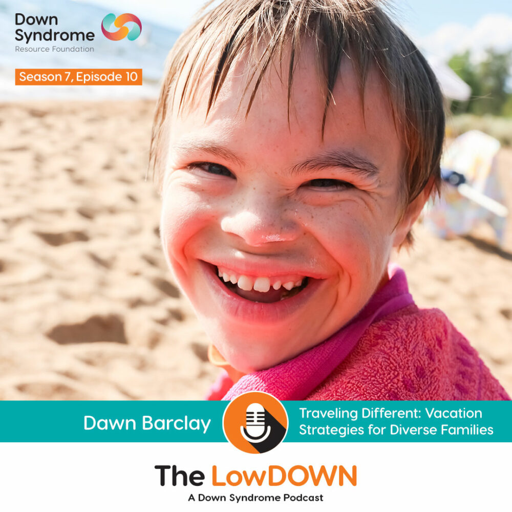 white boy with Down syndrome with a red towel wrapped around him smiles on a beach