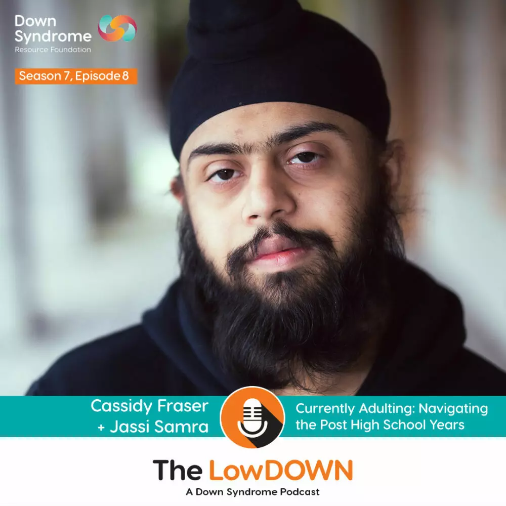 Asian man with Down syndrome with black beard, black turban and black hoodie smiles at the camera
