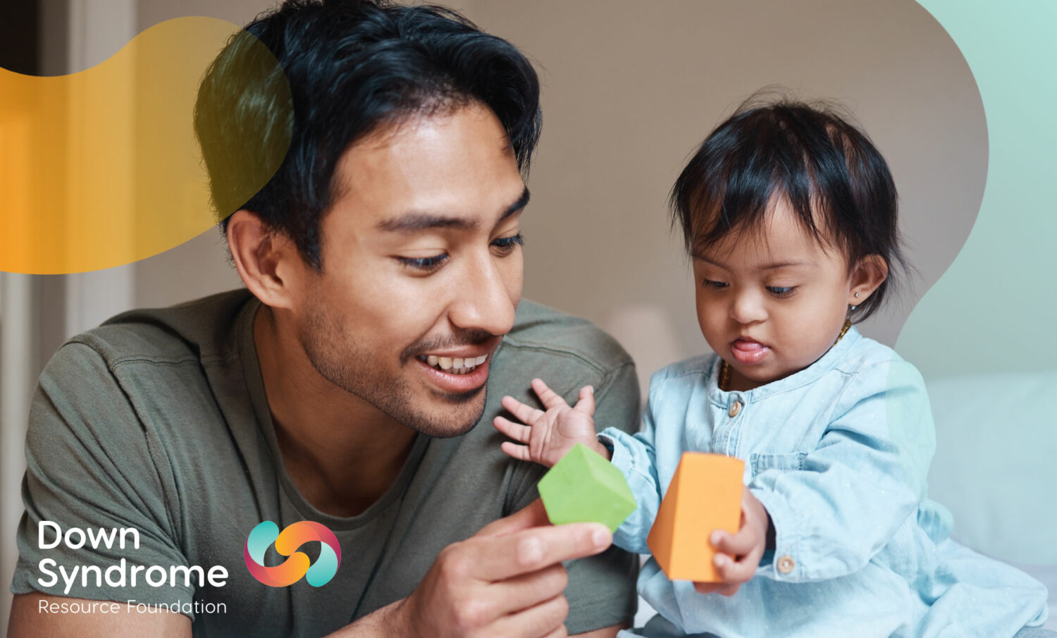 female asian toddler with Down syndrome plays blocks with her asian father