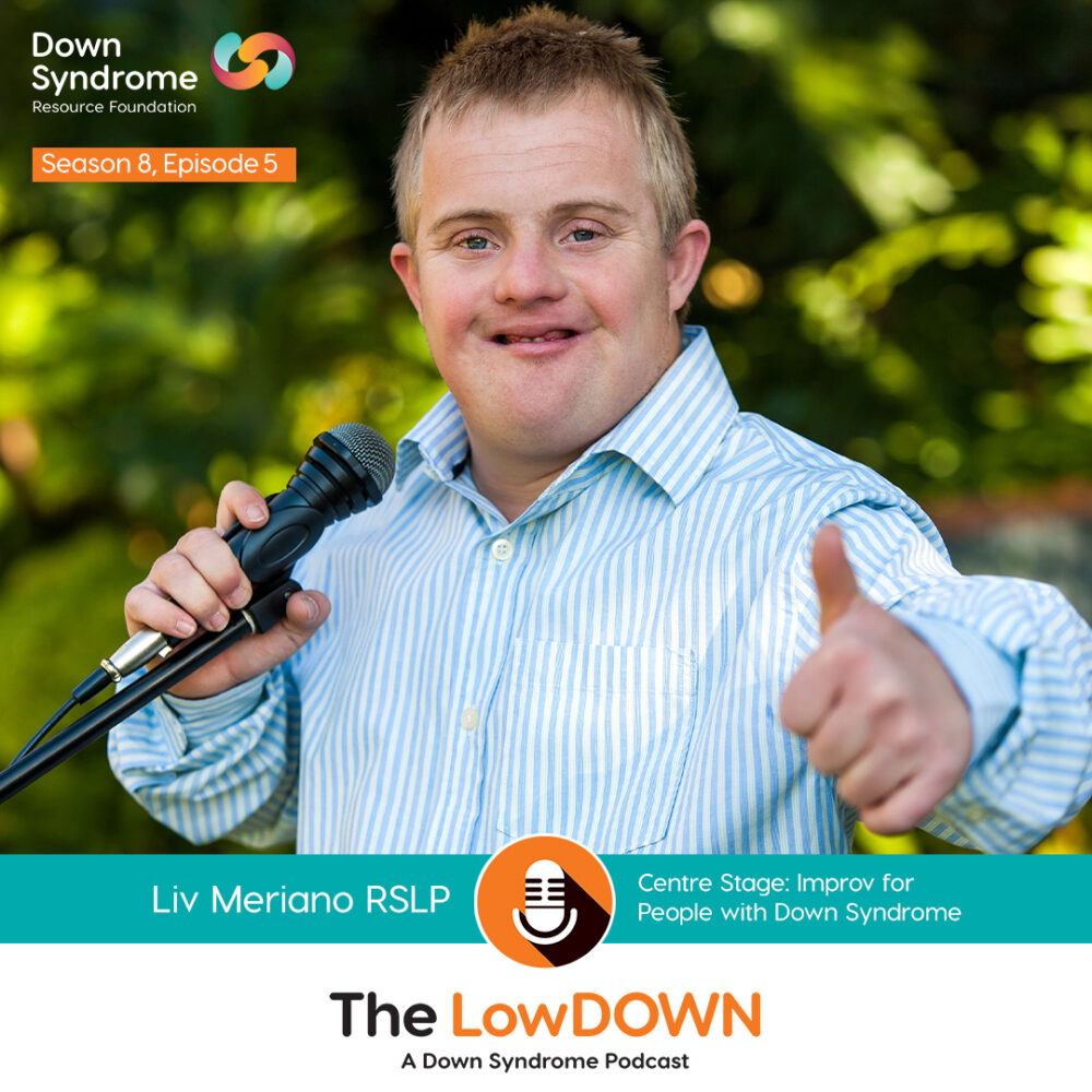 blonde haired white man with Down syndrome gives thumbs up while holding microphone outdoors