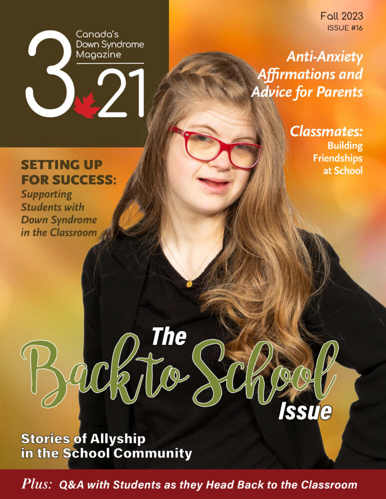 white female teenager with Down syndrome, with long dark blonde hair, black top and red glasses, smiles against fall background