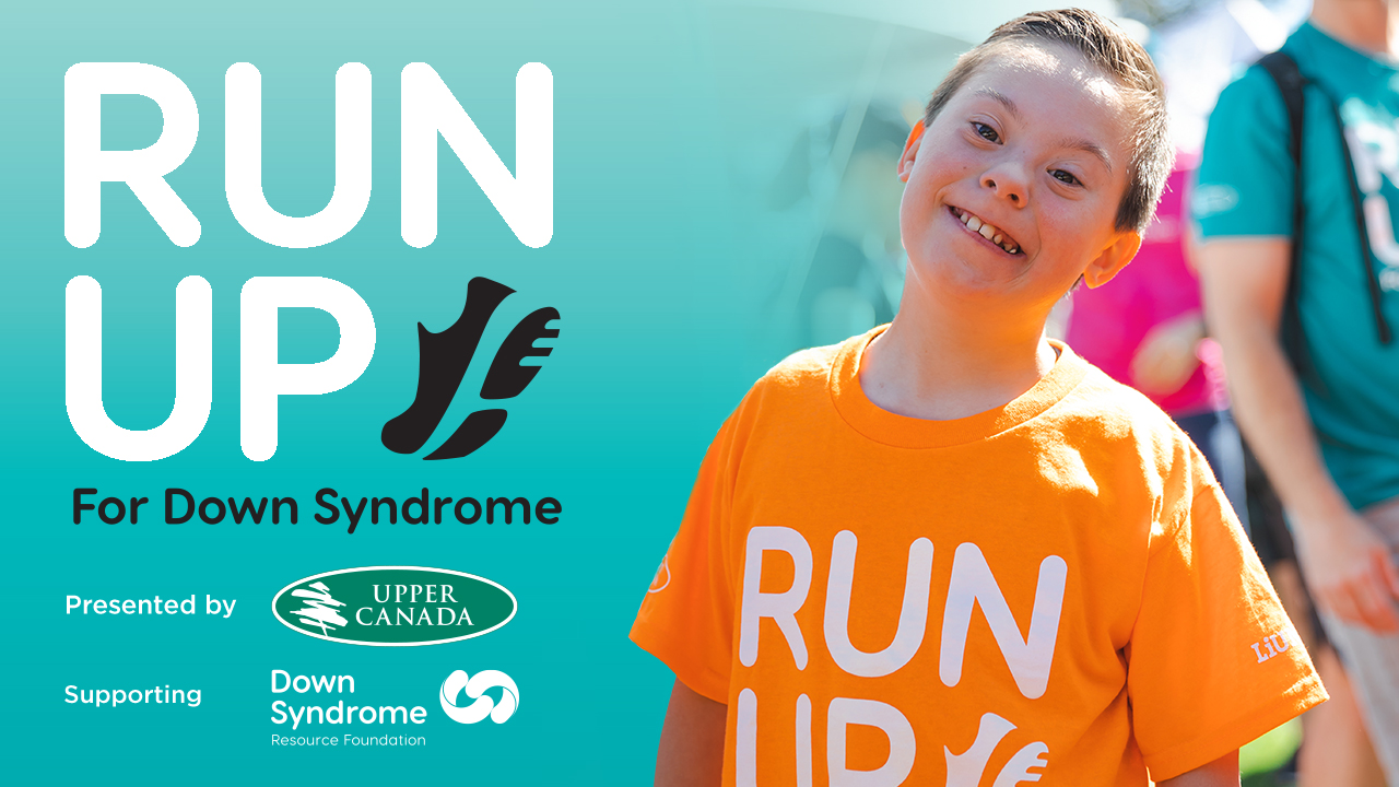 blonde haired boy with Down syndrome wearing orange Run Up for Down Syndrome t-shirt