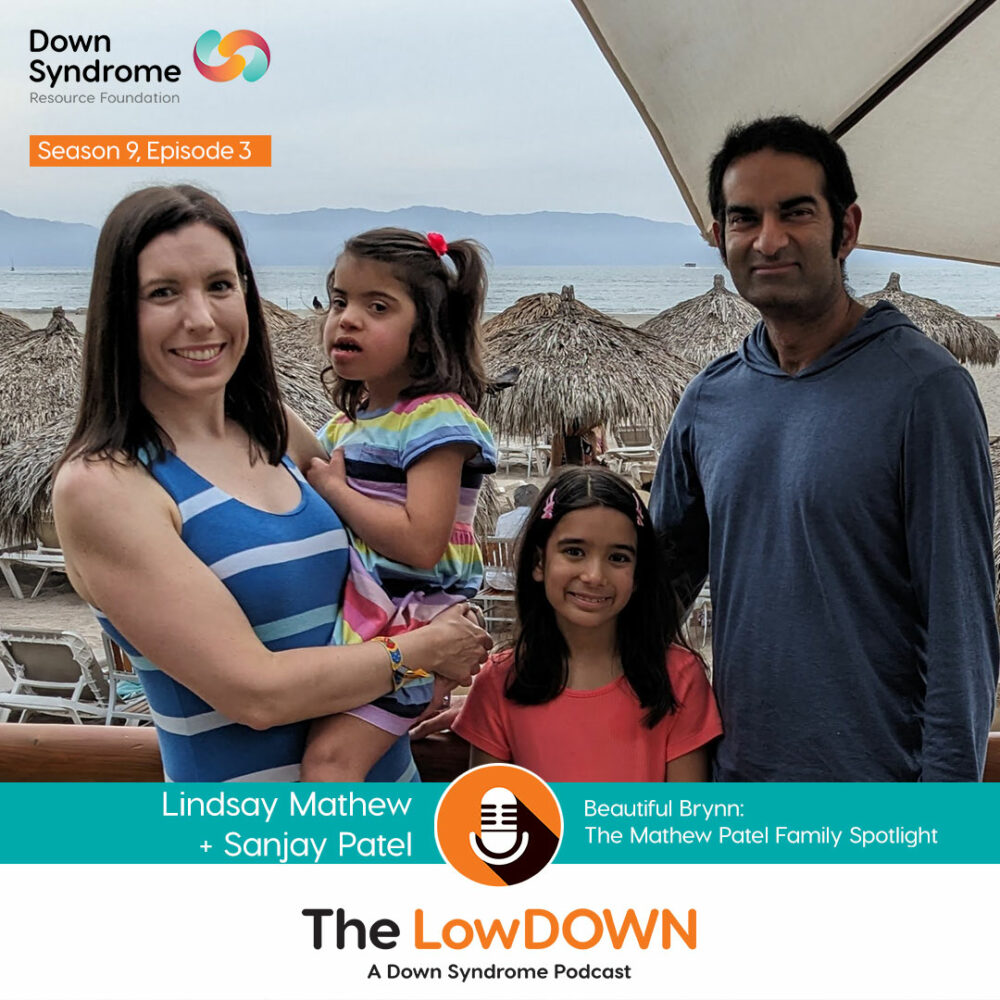 Mixed race family (mom, dad, and 2 girls, one with Down syndrome) standing outside at a resort