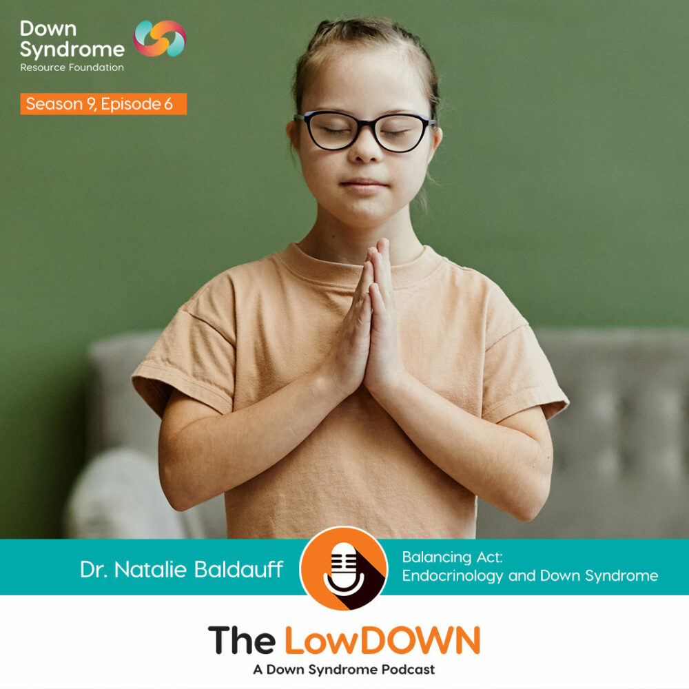 white girl with Down syndrome, with blonde hair, glasses and beige t-shirt, stands with palms touching in yoga pose